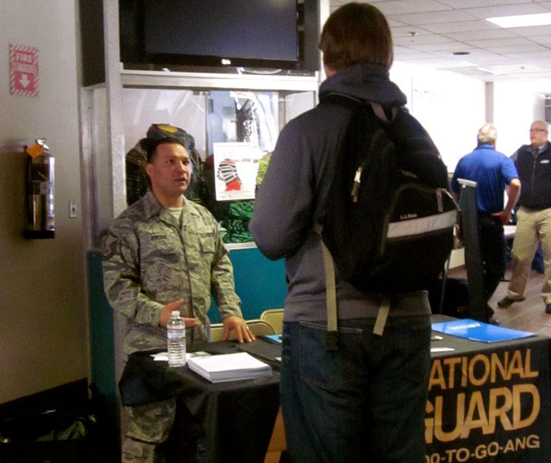 A Maine National Guard recruiter talks to a student at the "Thinking Outside the Box" college and career fair at Portland Arts and Technology High School in March 2013.