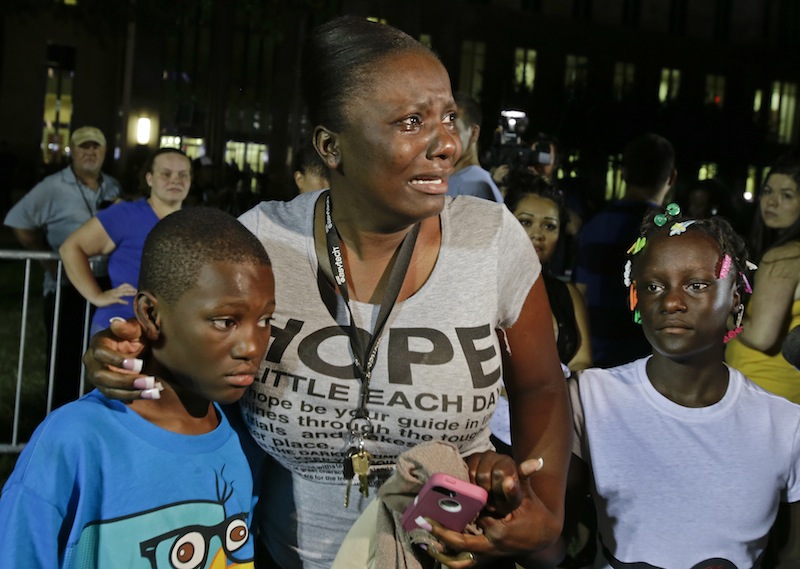 In this Saturday, July 13, 2013 file photo, Darrsie Jackson, center, reacts after hearing the verdict of not guilty in the trial of George Zimmerman, with her children Linzey Stafford, left, 10, and Shauntina Stafford, 11, at the Seminole County Courthouse, in Sanford, Fla. Zimmerman had been charged with the 2012 shooting death of 17-year-old Trayvon Martin. Nearly 70 years after Jackie Robinson was run out of town by the KKK, Sanford is absorbing what some see as another blow to race relations: Zimmerman's acquittal. (AP Photo/John Raoux, File)