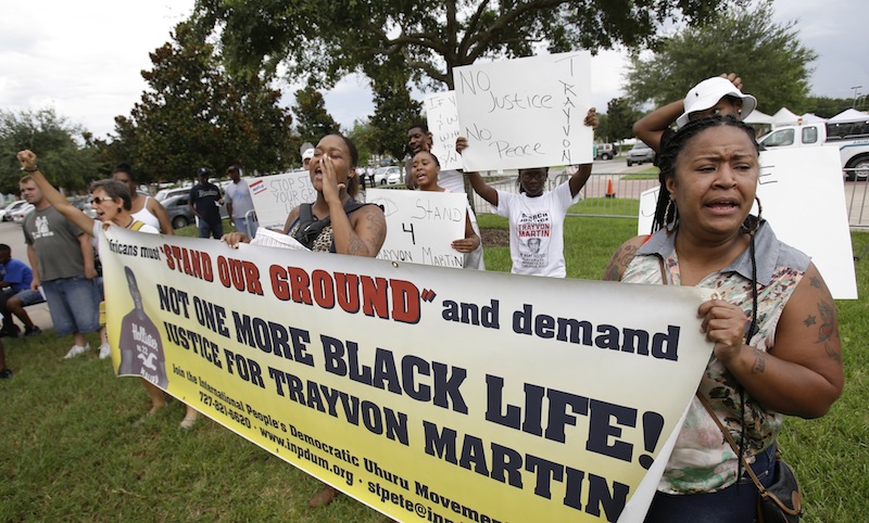 Demonstrators hold banners and signs and shout outside the Seminole County Courthouse, while the jury deliberates in the trial of George Zimmerman, Friday, July 12, 2013, in Sanford, Fla. Zimmerman has been charged with second-degree murder for the 2012 shooting death of Trayvon Martin. (AP Photo/John Raoux)