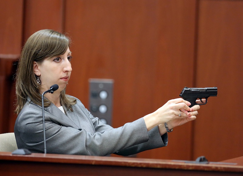 Amy Siewert, a firearms expert with the Florida Department of Law Enforcement, faces the jury as she demonstrates George Zimmerman's gun during the George Zimmerman trial in Seminole circuit court, in Sanford, Fla., Wednesday, July 3, 2013. Zimmerman is charged with second-degree murder in the fatal shooting of Trayvon Martin, an unarmed teen, in 2012. (AP Photo/Orlando Sentinel, Jacob Langston, Pool)