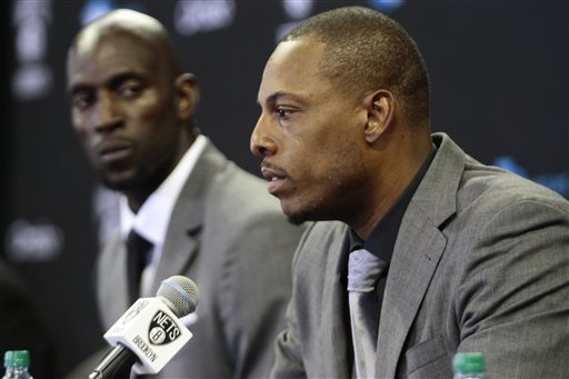 Brooklyn Nets' Kevin Garnett, left, listens as Paul Pierce speaks to the media during a news conference Thursday at Barlcays Center in New York.