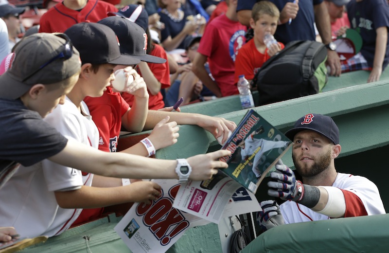 Second baseman Dustin Pedroia signs autographs during the first inning of an interleague baseball game at Fenway Park in Boston on Tuesday, July 2, 2013. (AP Photo/Elise Amendola)