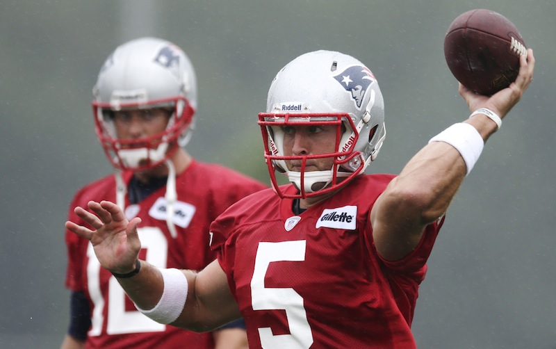 New England Patriots quarterback Tim Tebow, right, throws as starting quarterback Tom Brady looks on during NFL football training camp in Foxborough, Mass., Friday, July 26, 2013. (AP Photo/Charles Krupa). (AP Photo/Charles Krupa)