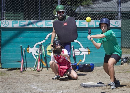 Laila, from Cairo, Egypt, bats during a softball game at the Seeds of Peace camp in Otisfield Friday. The summer camp brings together young people from countries at conflict.