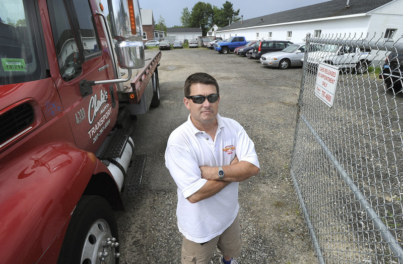 Ben Roussel of Charlie's Auto Transport stands by his truck and lot on Warren Avenue in Portland on Thursday, July 18, 2013.