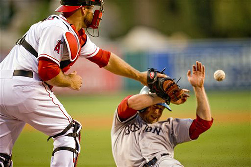 Boston's Daniel Nava beats the throw home to Los Angeles Angels catcher Chris Iannetta to score in the second inning Saturday in Anaheim, Calif. The Angels won in the 11th inning, 9-7.