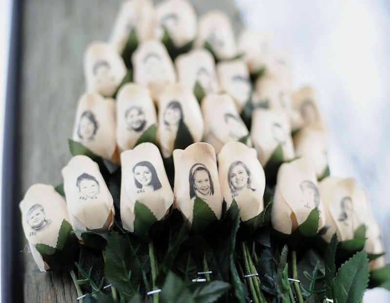 In this Jan. 14, 2013 file photo, white roses with the faces of victims of the Sandy Hook Elementary School shooting are attached to a telephone pole near the school on the one-month anniversary of the shooting that left 26 dead in Newtown, Conn. Some Newtown families have said they were given a voice late in the process of dispersing the millions of dollars in donated funds, and that the process has been bureaucratic, difficult, unpleasant, and has added to their pain. (AP Photo/Jessica Hill, File)