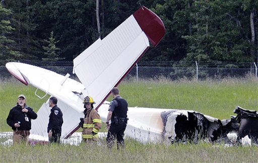 Police and emergency personnel stand near the wreckage of a fixed-wing aircraft that crashed Sunday at the Soldotna Airport in Soldotna, Alaska.