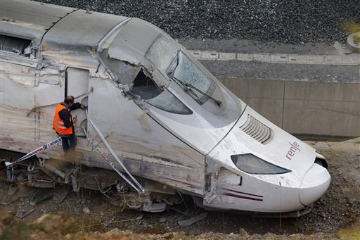 A rail worker checks the cabin of the train that was carrying 218 passengers when it hurtled off the tracks and slammed into a concrete wall. The Spanish rail agency has said the brakes should have been applied 2.5 miles before the train hit the curve.