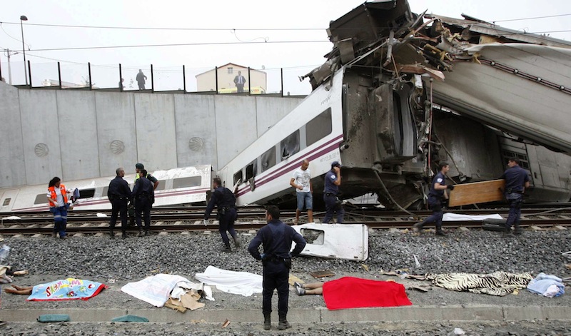 Emergency personnel respond to the scene of a train derailment in Santiago de Compostela, Spain, on Wednesday, July 24, 2013, where bodies are covered by towels. The train, carrying 218 passengers in eight carriages, hurtled off the tracks and slammed into a concrete wall, killing 79 people. (AP Photo/ El correo Gallego/Antonio Hernandez)