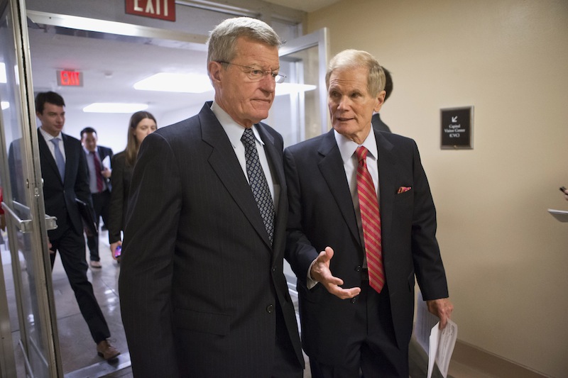Senate Finance Committee Chairman Sen. Max Baucus, D-Mont., left, and Sen. Bill Nelson, D-Fla., right, join other senators in the rush to the Senate floor on Capitol in Washington, Wednesday, July 10, 2013, for a vote to end debate on the Democrats' plan to restore lower interest rates on student loans one week after Congress' inaction caused those rates to double. The White House and most Senate Democrats favored restoring interest rates on subsidized Stafford loans to 3.4 percent for another year, but lawmakers failed to muster the necessary 60 votes to overcome a procedural hurdle. (AP Photo/J. Scott Applewhite)