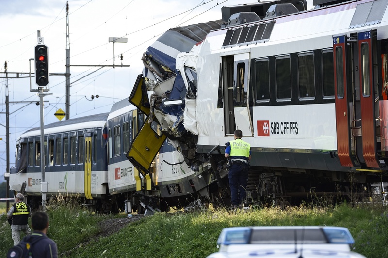 Police inspect the site where two passenger trains collided head-on in Granges-pres-Marnand, western Switzerland, on Monday.