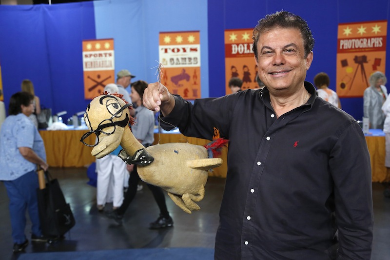 This June 22, 2013 photo released by PBS shows a man named Joe holding a Max Brother prop duck during the taping of the popular appraisal show "Antiques Roadshow," in Anaheim, Calif. Top-rated PBS series "Antiques Roadshow" is on the move, taping programs in eight U.S. cities for its upcoming 18th season. (AP Photo/PBS)