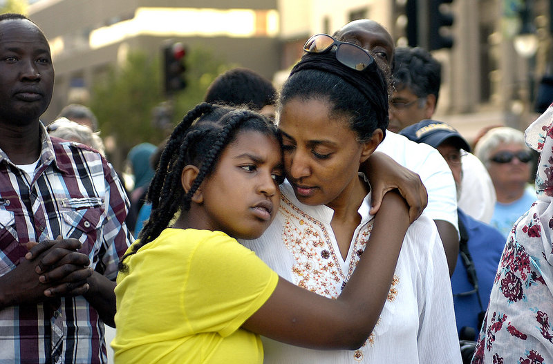 Wala Mohamed, left, in yellow shirt, hugs her mother, Abeir Ibrahim, of Portland, while attending a rally in Monument Square Monday, July 22, 2013, in memory of Trayvon Martin, the young black man who was killed last year in Florida. George Zimmerman, who stood trial for the killing, was found not guilty last week.
