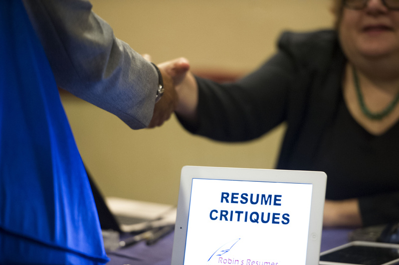 A job seeker stops at a table offering resume critiques during a job fair in Atlanta in May.