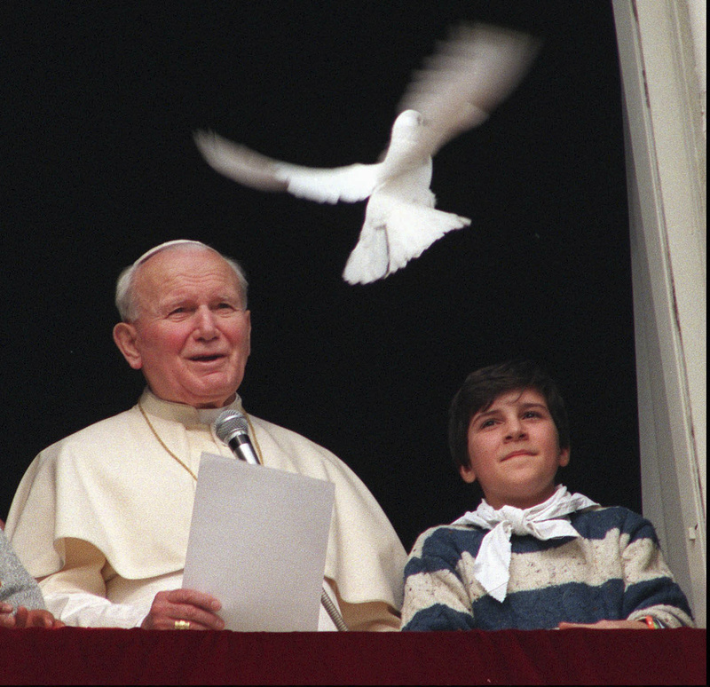 Pope John Paul II looks at a dove after delivering a blessing from the window of his studio overlooking St. Peter's Square at the Vatican in 1996. Pope Francis has cleared John Paul II for sainthood, approving a miracle attributed to his intercession.