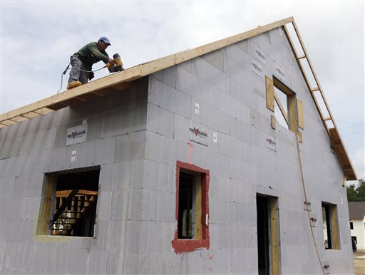 A worker installs the roof of a zero net energy home in New Paltz, N.Y. The rafters will be heavily insulated and combined with castle-thick walls, insulated concrete slab below and triple-paned windows to create a "building envelope" that makes each house nearly airtight before extra ventilation is installed.