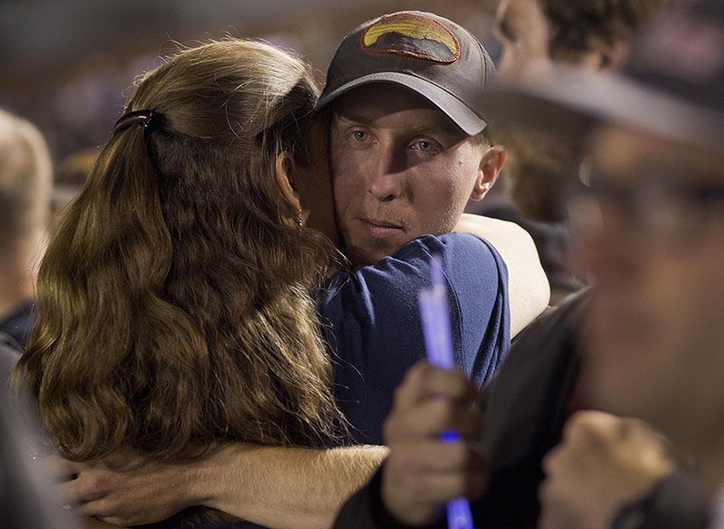 Firefighter Brendan McDonough embraces a mourner near the end of a candlelight vigil in Prescott, Ariz. on Tuesday, July 2, 2013. McDonough was the sole survivor of the 20-man Granite Mountain Hotshot Crew after an out-of-control blaze killed the 19 on Sunday near Yarnell, Ariz.