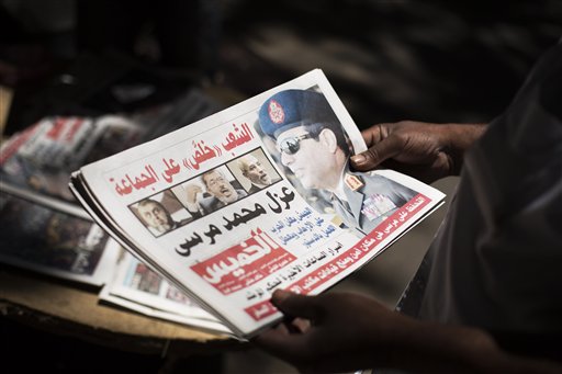 Egyptian man holds a newspaper the news near Mesaha Square, in Cairo , Thursday. The chief justice of Egypt's Supreme Constitutional Court was sworn in Thursday as the nation's interim president, taking over hours after the military ousted the Islamist President Mohammed Morsi. (AP Photo/ Manu Brabo)