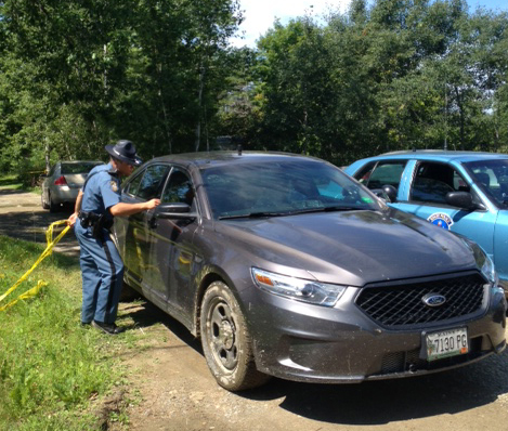 A Maine state trooper speaks with a detective leaving the home where a man's body was discovered at 24 Main St. in Detroit on Thursday morning.