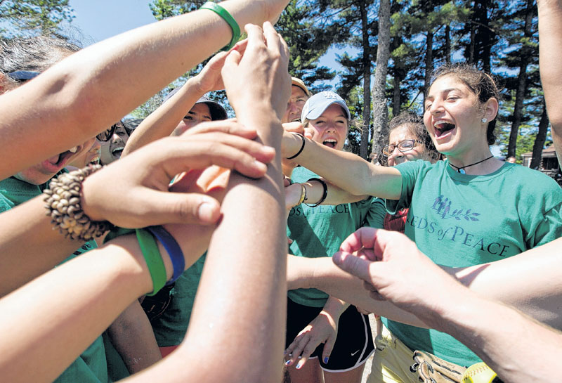 Campers cheer before taking the field for a softball game at the Seeds of Peace camp in Otisfield. The summer camp brings together young people from countries in conflict.