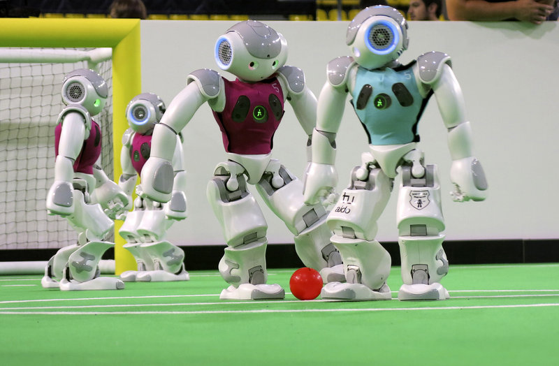 Robots in the "standard platform" division battle for the ball. RoboCup organizers plan to merge techniques to create a team that can win a man-vs.-machine matchup.