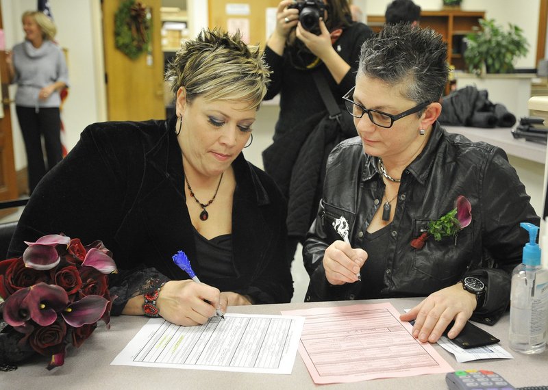 Lisa Gorney, left, and Donna Galluzzo, both of Portland, sign their marriage license at Portland City Hall on Dec. 29, 2012. Legally married same-sex couples who want “to fully claim first-class citizenship” should call each other “husband” or “wife,” a reader says.