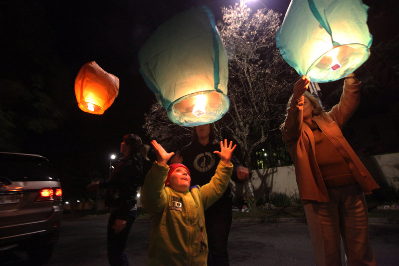 People light up and release lanterns outside Nelson Mandela’s house in Johannesburg, South Africa, on Monday. Mandela remains in critical condition at a hospital in Pretoria.
