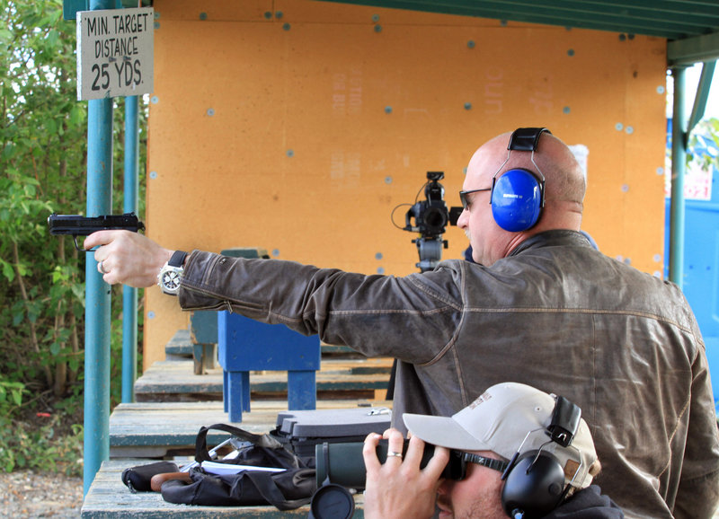 Mark Kelly fires .22-caliber handgun at an Alaska shooting range on Tuesday. He and his wife, former U.S. Rep Gabrielle Giffords, met privately with 11 Alaska gun owners.