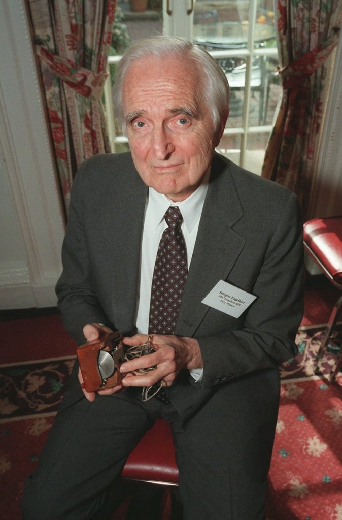 Doug Engelbart holds an early working model of his computer mouse. He patented the device in 1970 but never profited much from his invention.