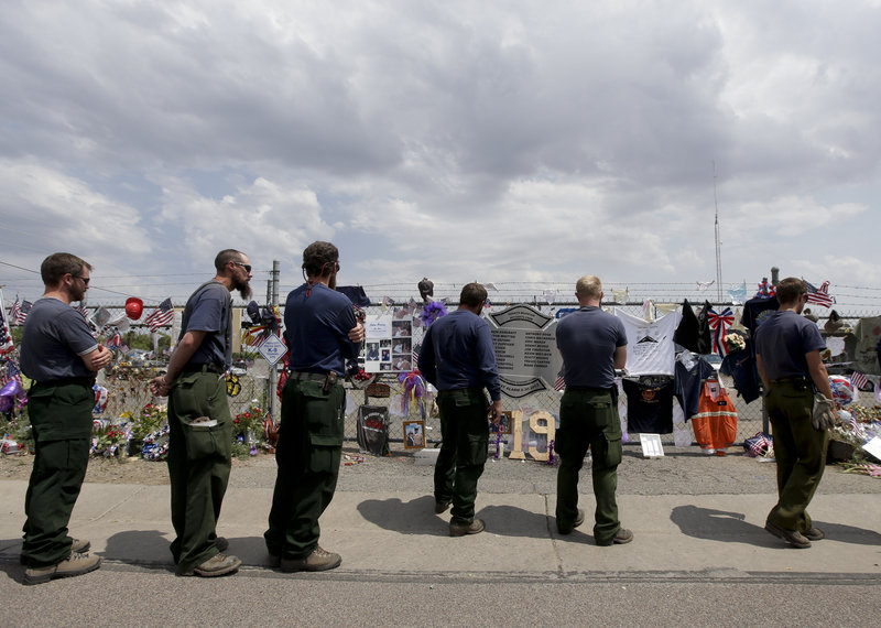 Fire crew members from Island Park, Idaho, pay their respects Thursday at a memorial in Prescott, Ariz., to the 19 firefighters killed Sunday.