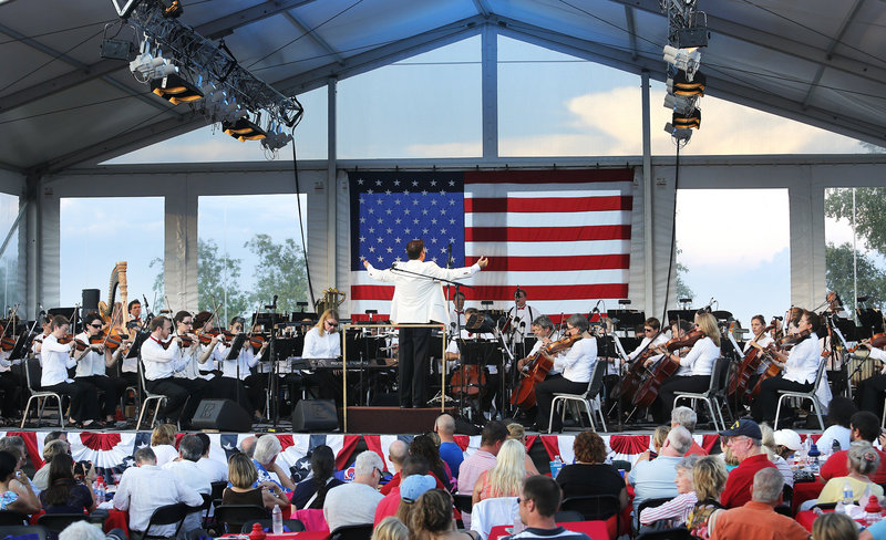 Maestro Robert Moody conducts the Portland Symphony Orchestra on the covered stage on Cutter Street. The PSO performed superhero-themed popular music and patriotic standards.