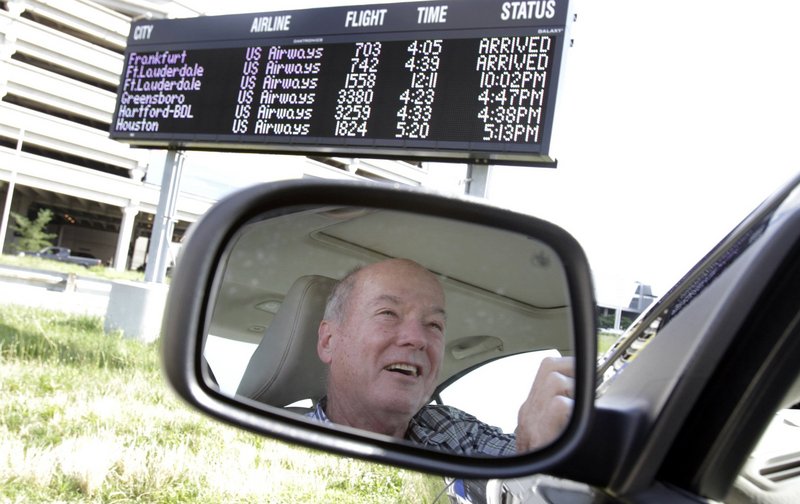 Joe McGuriman of Lansdale, Pa., parks in front of one of three electronic flight status boards at the cellphone lot at Philadelphia International Airport on June 19.