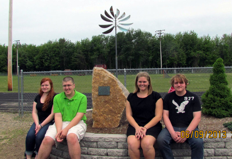 The officers of the Wells High School Class of 2012, from left, Logan Snyder, secretary; Michael Valente. treasurer; Whitney Lallas, president; and Connor Sweatt, vice-president, posing with their class gift, the sculpture in the background.
