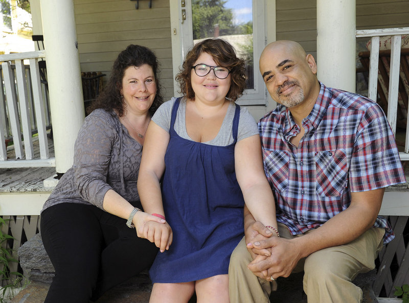In this June 20, 2013 photo, Becky Bluh, left, and Tony Derricotte pose for a photo with their daughter, Cameron Bluh-Derricotte, center, at their home in Greenfield, Mass. The Make-A-Wish Foundation has arranged a trip to London for Cameron, who has a rare autoimmune disorder. (AP Photo/Greenfield Recorder, Paul Franz)