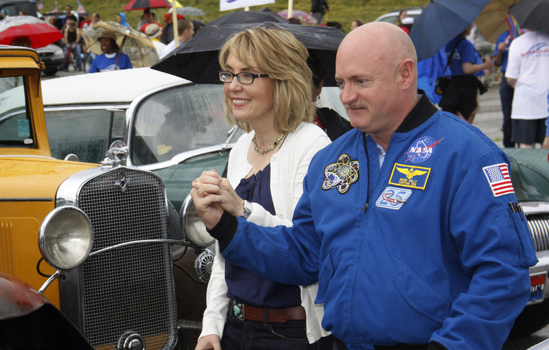 Former U.S. Rep. Gabrielle Giffords and her husband, former astronaut Mark Kelly, walk with supporters to a car as they take part in a parade in Northside, Ohio, on Thursday. Giffords, who was wounded in a mass shooting in 2011, is coming to Maine on Saturday with her husband to discuss gun owners’ rights and responsibilities.