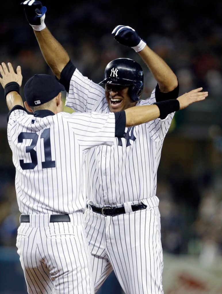Vernon Wells, right, celebrates with Ichiro Suzuki after hitting an RBI single in the ninth inning Friday night to give the Yankees a 3-2 home win over the Orioles.