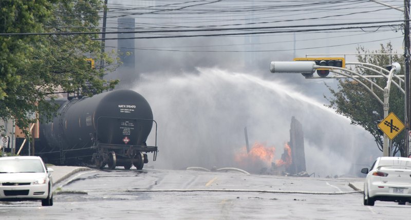 Smoke and fire rise from railway cars that were carrying crude oil after derailing in downtown Lac Megantic, Que., Saturday, July 6, 2013. A large swath of Lac Megantic was destroyed Saturday after a train carrying crude oil derailed, sparking several explosions and forcing the evacuation of up to 1,000 people. (AP Photo/The Canadian Press, Paul Chiasson)