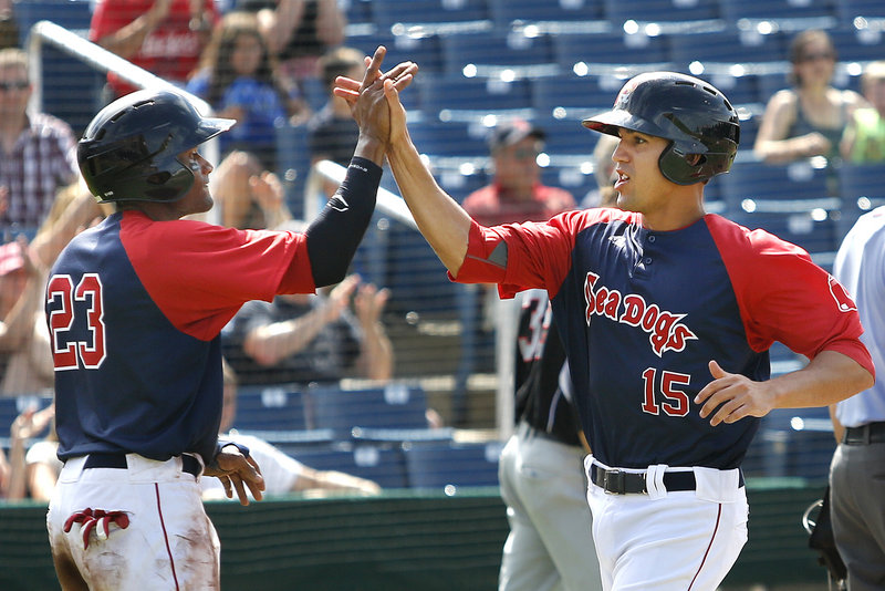 Sea Dogs Tony Thomas, left, and Derrik Gibson celebrate after scoring the tying and go-ahead runs on Shannon Wilkerson’s two-out single in the eighth inning of Portland’s 4-3 win over New Britain.