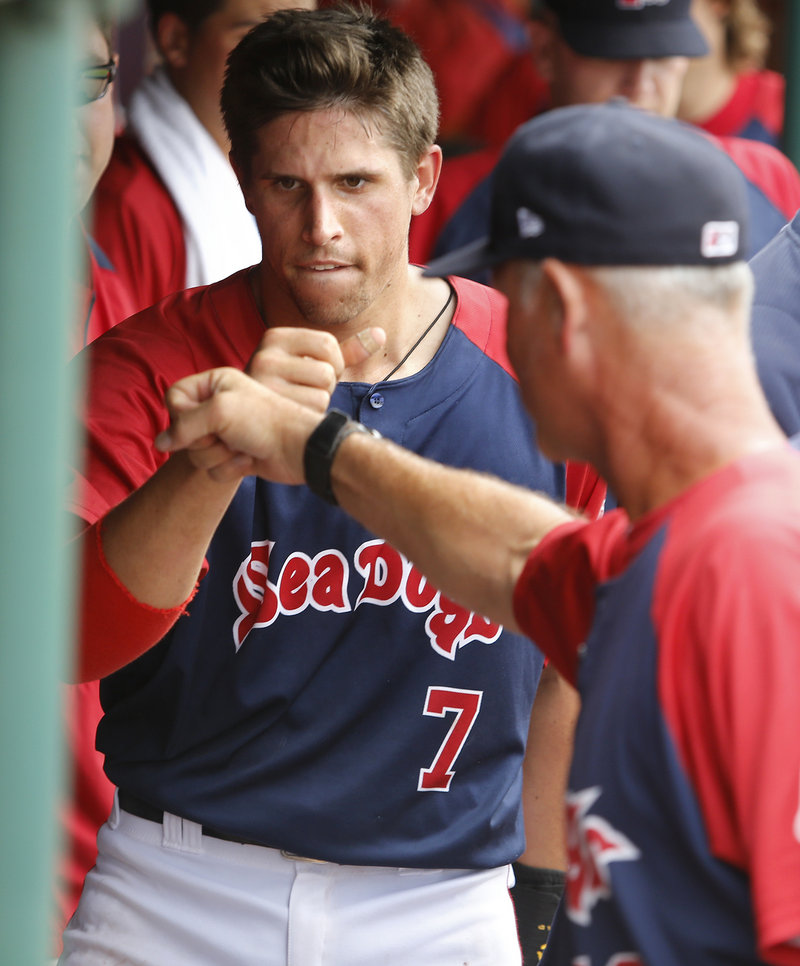 Garin Cecchini is met by Portland hitting coach Bob Kipper after doubling and scoring in the sixth inning Sunday.