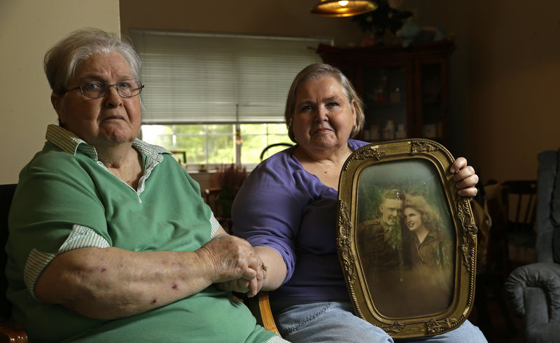 Shelia Reese, right, sits with her mother Chris Tench in Chapel Hill, N.C. Reese is holding a portrait of her mother and her father, Kenneth F. Reese, a soldier who is still listed as MIA – missing in action – from the Korean War.