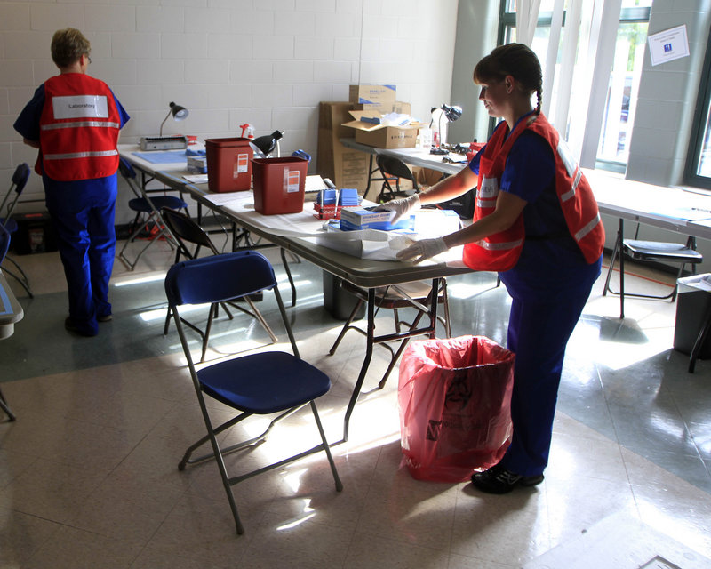 Laboratory scientists set up a lab in a middle school in Stratham, N.H., in this Aug. 11, 2012 file photo. Scientists were testing people for hepatitis C related to an outbreak at the Exeter Hospital allegedly caused by medical technician David Kwiatkowski.