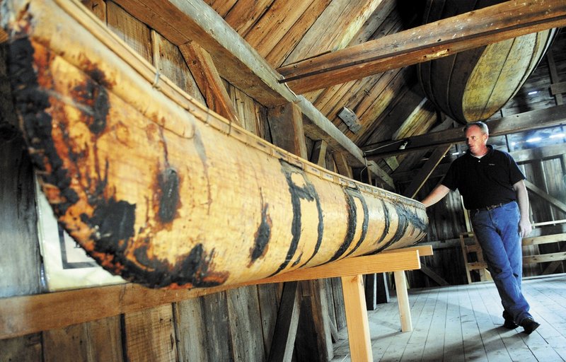 Tom Desjardin, a Parks and Public Lands historian with the Maine Department of Agriculture, Conservation and Forestry, inspects an 18th-century birchbark canoe built by Indians on display at the Maj. Reuben Colburn House State Historic Site in Pittston. The Kennebec Historical Society will hold a program Saturday that features a collection of boats.