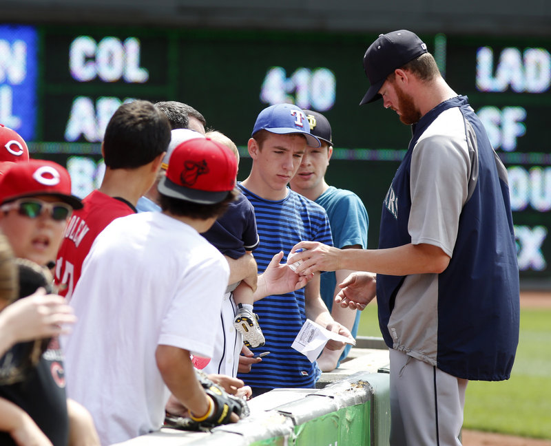 Mariners reliever Charlie Furbush of South Portland signs an autograph before Seattle’s game with the Reds at Cincinnati on Sunday.