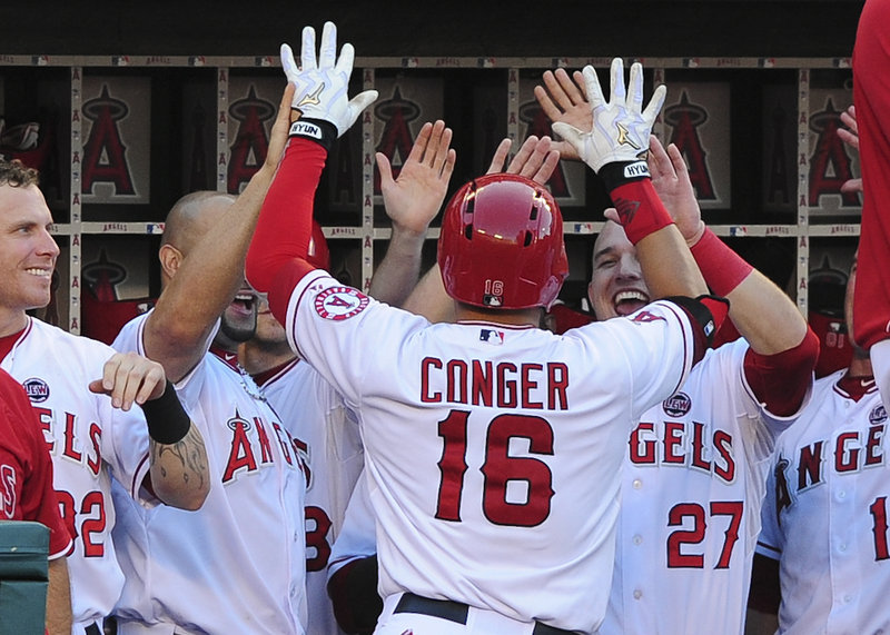 Hank Conger is greeted in the dugout by Mike Trout (27) and other teammates after his home run in the fifth inning gave the Angels a 2-0 lead. Trout also homered for the second straight game, helping the Angels to a 3-0 victory.