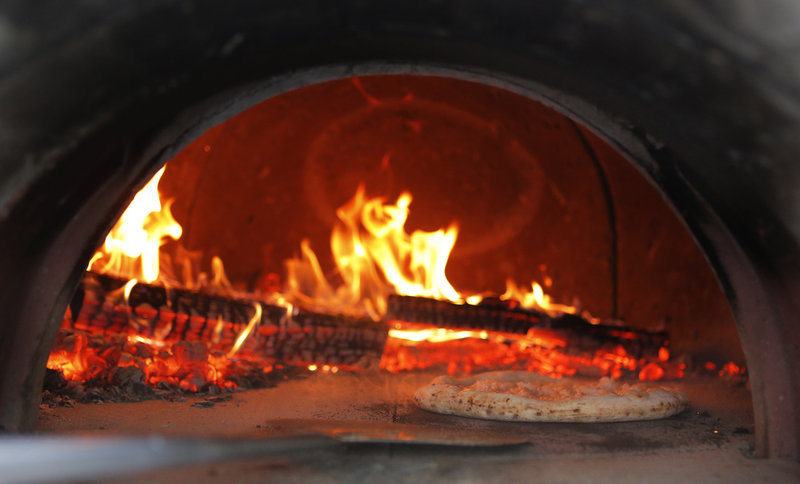 A pizza cooks in an oven at Jillyanna’s.
