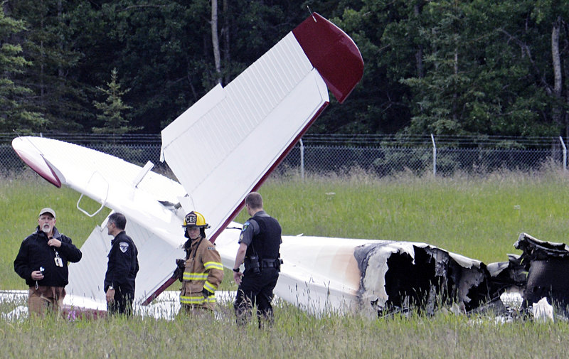 Emergency personnel stand near the wreckage of a fixed-wing aircraft that crashed Sunday at the Soldotna Airport in Soldotna, Alaska.