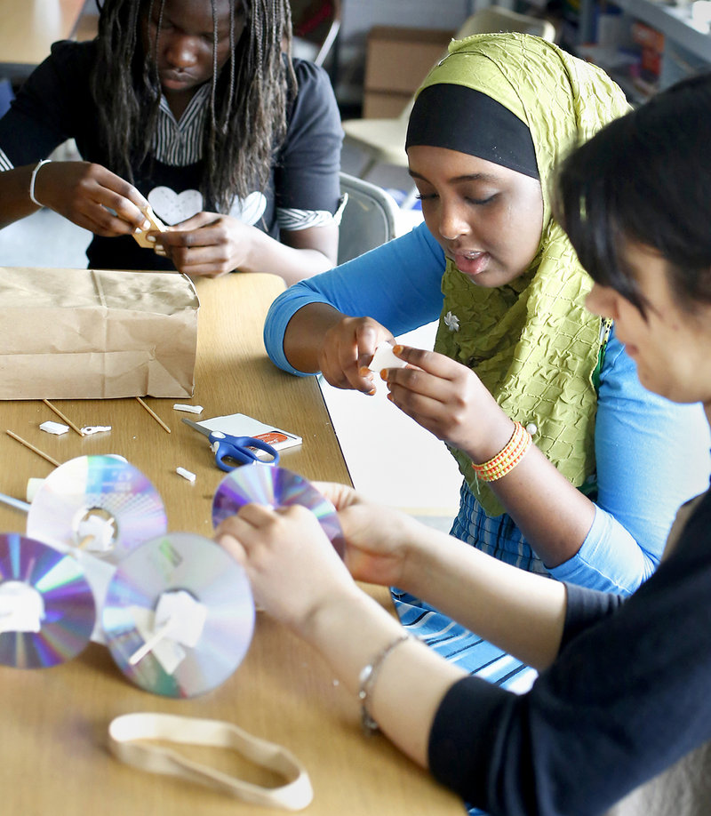 Lona Peter, 15, from Casco Bay High School, upper left, Sahra Ahmed, 14, Deering High School, middle, and Nilab Nasrat, 19, from Portland High School, build a mousetrap car at the Real School on Mackworth Island in Falmouth on July 10, 2013. A group of 16 girls are wrapping up a free, three-week STEM (science, technology, engineering, math) program, working with local companies to solve "real world" problems.