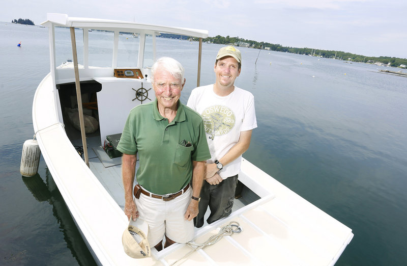 Eugene Story, left, and Eric Graves aboard their electric lobster boat July 8 in Boothbay Harbor.
