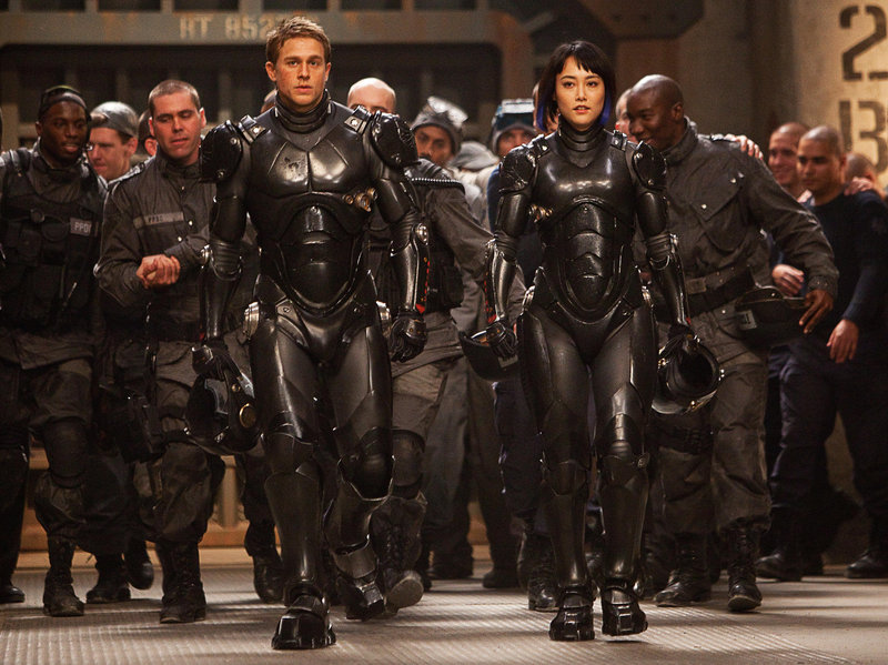 Charlie Hunnam and Rinko Kikuchi pilot a huge robot in the war against creatures from under the ocean in “Pacific Rim.”
